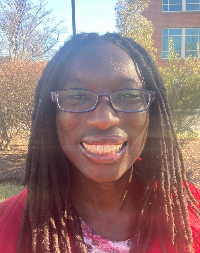 Marie D wearing glasses and a red winter coat.